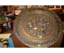 LARGE BRASS CHARGER, THE CENTRE WITH AN INNKEEPER'S SCENE SURROUNDED BY A FLORAL TYPE BORDER, 72CM