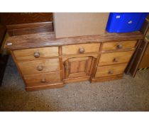 VICTORIAN PINE DRESSER BASE WITH SEVEN DRAWERS WITH CENTRAL PANELLED CUPBOARD DOOR WITH TURNED