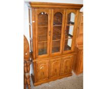 BEECHWOOD FRAMED BOOKCASE FITTED WITH TWO GLAZED DOORS, THE BASE FITTED WITH THREE PANELLED CUPBOARD