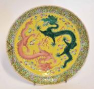 Chinese plate, the yellow ground decorated with two dragons in a famille vert and famille rose