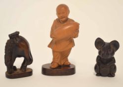 Carved Oriental figure of a boy together with two further wooden carvings, model of a gazelle and