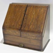 Early 20th century oak stationery cabinet, the sloping front enclosing fitted interior, letter racks