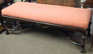 Large rectangular oak bench, pink upholstered seat over a plain frieze and raised on balustered