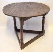 18th century oak cricket table, the oval top raised on a triangular support with ring turned columns