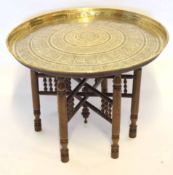 Benares brass topped circular table on a treen folding support, 68cm diam