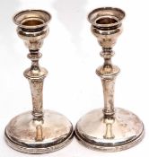 Two George V candlesticks, each with fixed ogee sconces and knopped columns on spreading circular