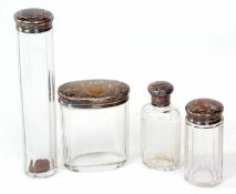 Mixed Lot: four silver lidded and clear cut glass toiletry bottles, each with engraved covers with