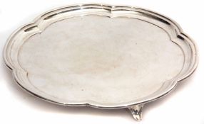 George VI silver salver of lobed circular form with polished field and raised on three cast and