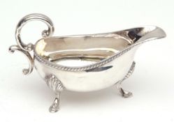 Elizabeth II gravy boat, with cast and applied gadrooned border and flying C-scroll handle on