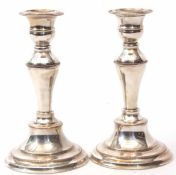 Two modern silver on copper single candlesticks, each with detachable nozzles and urn shaped sconces