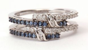 Modern precious metal diamond and sapphire cluster ring, a stylised design of entwined split bands