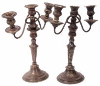 Two 20th century electro-plated three light candelabra, each with urn shaped sconces and scrolling