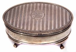 George V dressing table casket of oval form, the hinged cover with engine turned decoration and