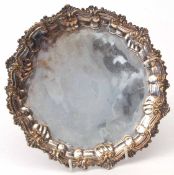 19th century silver on copper small salver of circular form with shaped foliate border and raised on