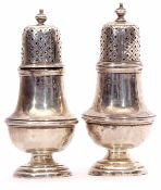 Two George V pepper casters, each of typical baluster form with girdled bodies and pierced pull