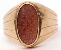 Large yellow metal and sandstone ring, the oval sandstone panel bezel set and raised between