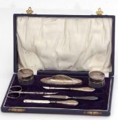 George V cased manicure set comprising two silver lidded and faceted glass circular pots, three