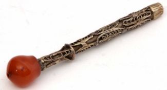 Far Eastern base metal opium pipe of cylindrical form with filigree detail and amber coloured