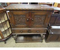 EARLY 20TH CENTURY OAK CUPBOARD ON STAND FITTED WITH TWO CUPBOARD DOORS WITH CARVED DETAIL OVER