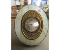 HOWELL JAMES & CO OVAL EASEL BACK CLOCK WITH GLASS SURROUND AND BRASS CENTRE WITH SILVERED DIAL