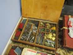 Wooden box containing a large and varied selection of small Meccano pieces including nuts, bolts,