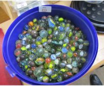 Plastic tub containing a large quantity of assorted glass marbles, various types and ages