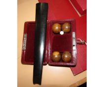 Cased miniature carpet bowls set, each bowl approx 2.5cm diam together with an ebony wooden runner