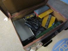 Vintage suitcase containing various 00 gauge rolling stock, 1960s Tri-ang track side accessories etc