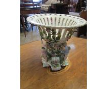 CONTINENTAL PORCELAIN FLOWER ENCRUSTED CENTRE PIECE MOUNTED WITH THREE PUTTI WITH AN OPEN WORK