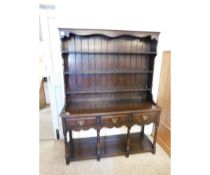 REPRODUCTION OAK FRAMED DRESSER WITH THREE FIXED SHELVES WITH PANEL BACK, BASE FITTED WITH THREE