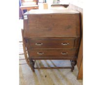 OAK FRAMED DROP FRONTED BUREAU FITTED WITH TWO DRAWERS ON A TURNED BASE