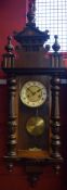 Early 20th century walnut cased Vienna type wall clock, the overhanging cornice with double height