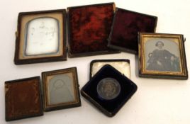 Group of vintage leather cased photographs viz Daguerrotype of family group, ambrotypes of ladies (