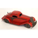 Vintage red tin plate clockwork racing car with plain metal mounts and wheels, stamped "British