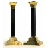 Brass finished and black lacquered stemmed candlesticks on stepped bases, 25cm tall (2)