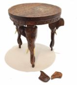 Eastern hardwood occasional table profusely carved throughout supported on three heavily carved