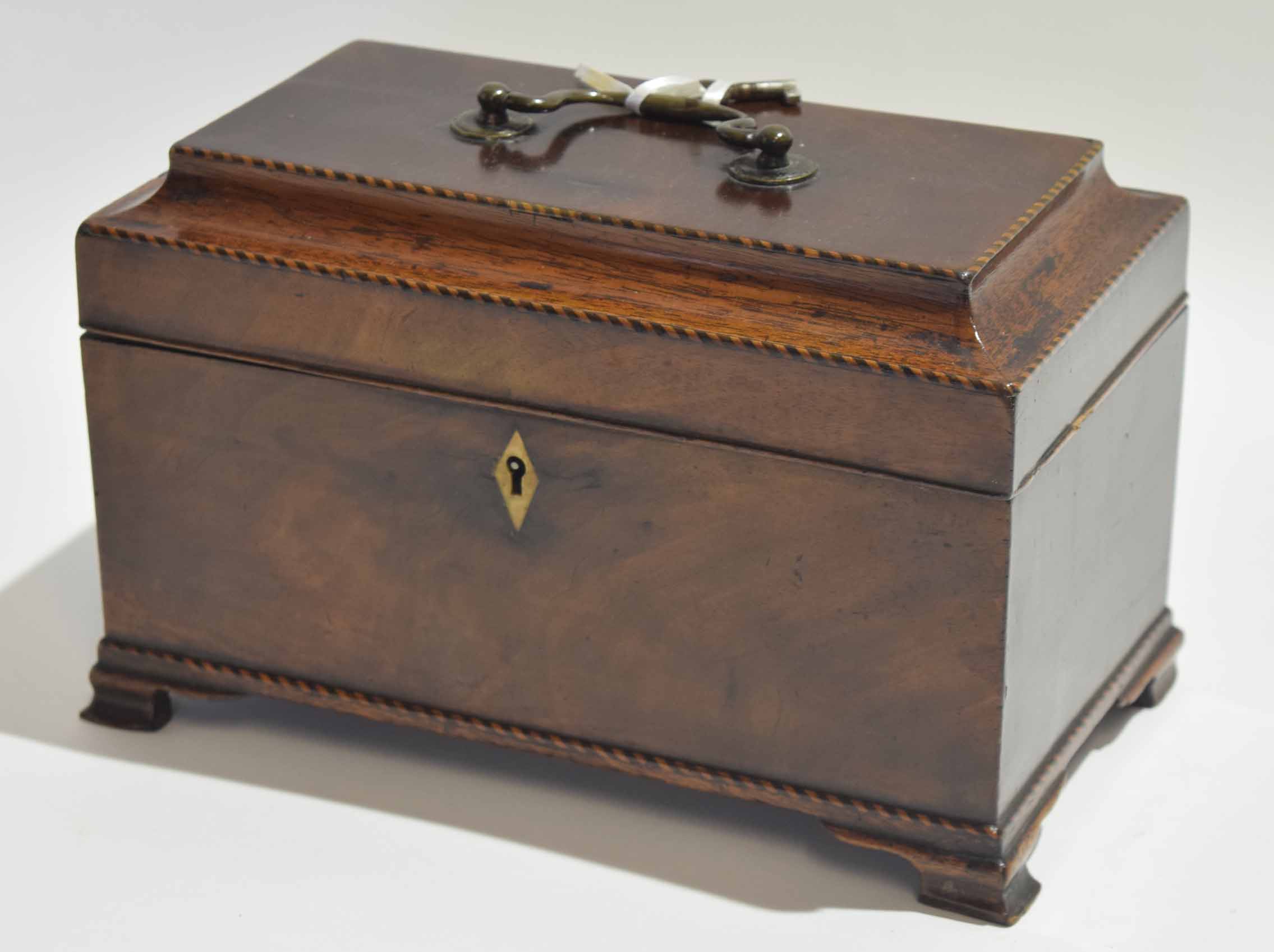 Early 19th century mahogany tea caddy with ogee top, central carry handle enclosing a three-