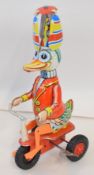 Late tinplate of a circus Duck riding a tricycle. Height approx 20cm