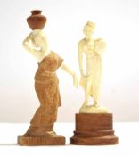 Two ivory type models of ladies, one carrying a water jug on her head, both on wooden mounts,