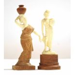 Two ivory type models of ladies, one carrying a water jug on her head, both on wooden mounts,