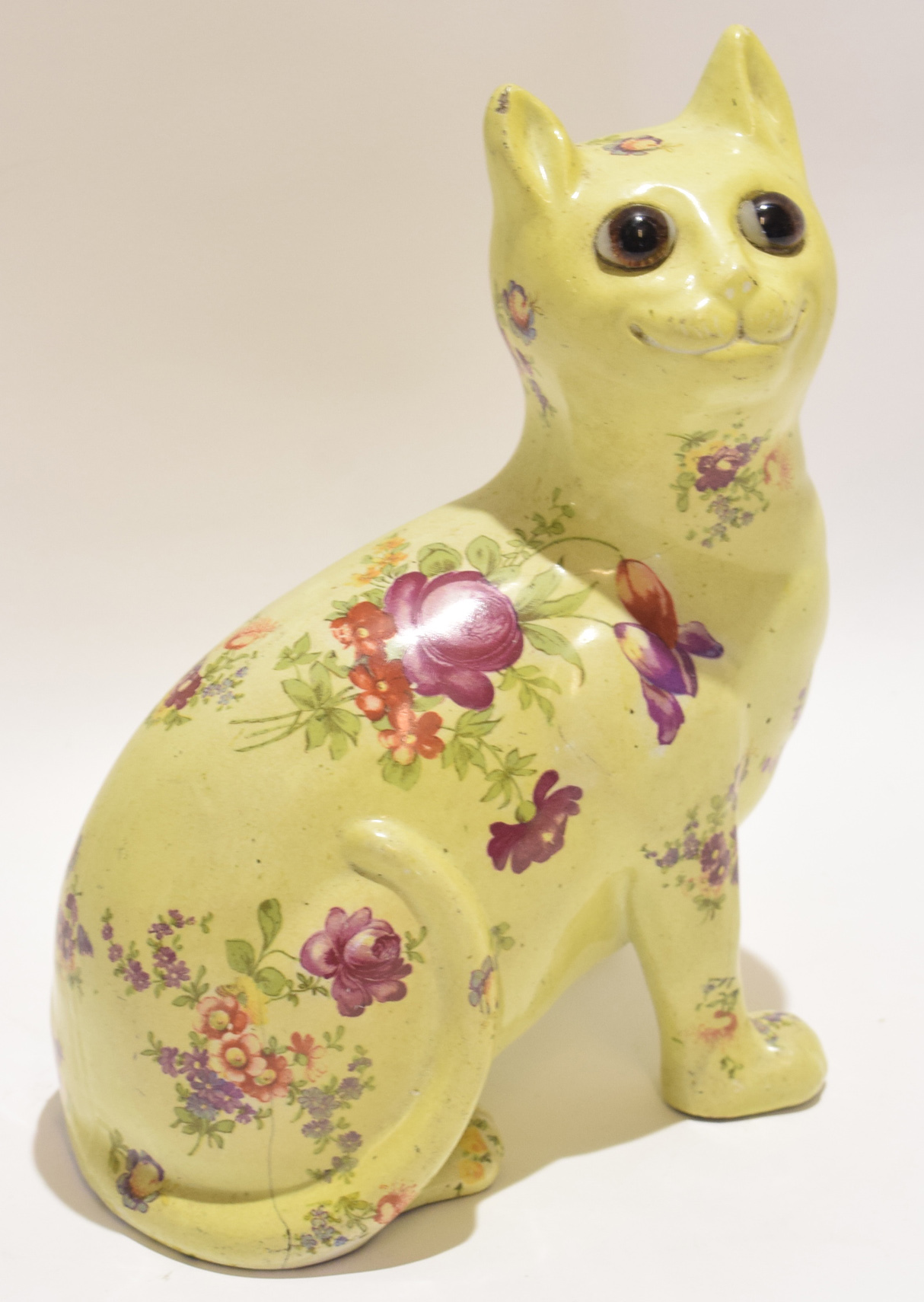 Galle style pottery cat with glass eyes, the body with floral decoration, 24cm high