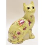 Galle style pottery cat with glass eyes, the body with floral decoration, 24cm high