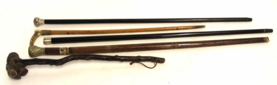 Group of four walking canes, three with silver metal mounts and a knobkerrie stick