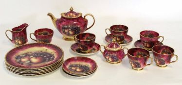 Staffordshire tea set, the red ground decorated with a printed fruit design, comprising tea pot,
