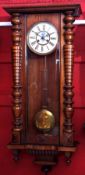 Early 20th century walnut cased Vienna type wall clock with overhanging cornice and baluster