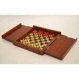 Mahogany framed folding travelling chess set with a set of stained bone chess pieces (incomplete),