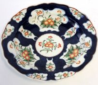 Worcester blue ground dish, the panels decorated with Kakiemon floral design, 23cm diam