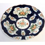 Worcester blue ground dish, the panels decorated with Kakiemon floral design, 23cm diam