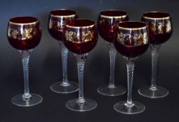 Collection of six ruby coloured wine glasses with an overlaid gilt design of fruiting vines, the