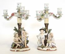 Pair of Continental porcelain Sitzendorf candelabra modelled as children by a tree stump, the